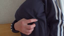 爆乳女性が、自宅で室内エクササイズを始める前に、小さくて白いビキニを着て、そのデカパイを誇示している。